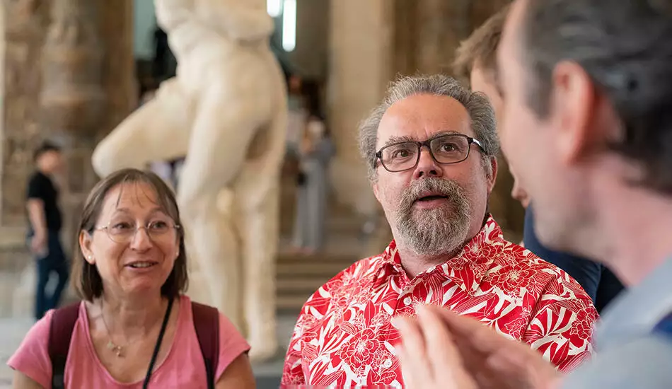 Guest listening to a guide in the Louvre